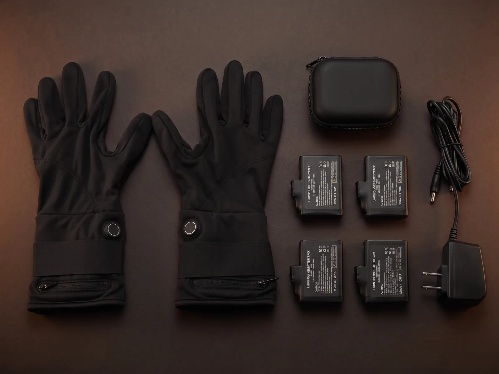The full box contents laid out: a pair of gloves, four batteries, and the dual-head charger